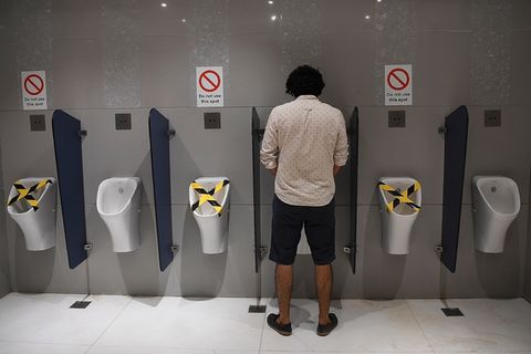 Mann an einem Urinal in Neu Delhi