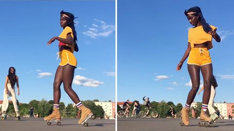 Eine schwarze junge Frau in gelbem T-Shirt und Shorts tanzt auf Rollschuhen