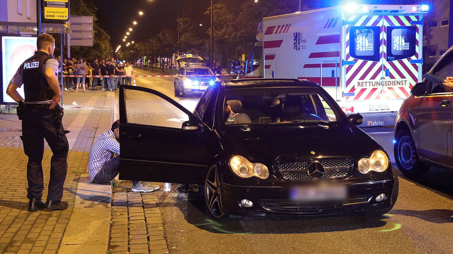 Polizisten untersuchen den Unfallwagen