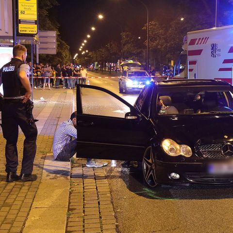 Polizisten untersuchen den Unfallwagen