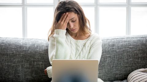Frau sitzt traurig vor dem Computer