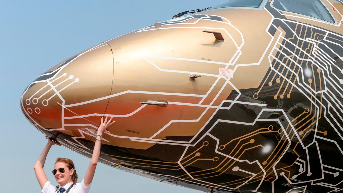 Diese Pilotin lässt sich auf der Messe Wings India 2020 in Hyderabad vor einer Embraer's E195-E2 mit der Sonderlackierung "Profit Hunter" fotografieren.