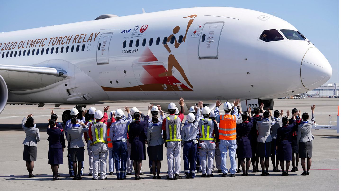 Hoffnungsvoll noch Mitte März auf dem Flughafen Tokio-Haneda: Bodenbesatzungen japanischer Fluggesellschaften winken vor dem Abflug dem Sonderflugzeug "Tokyo 2020 Go" zu, das das olympische Feuer von Griechenland nach Japan transportieren sollte. Bekanntlich wurden die Olympischen Sommerspiele 2020 abgesagt.