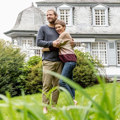 Ein Paar vor einem pompösen Haus