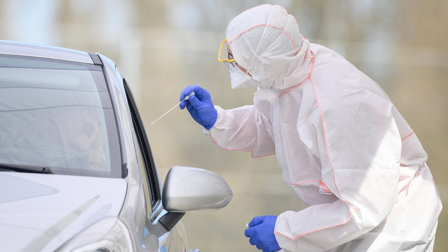 Ein Mitarbeiter führt in einem Corona-Abstrichzentrum einen Test auf das Coronavirus Sars-Cov-2 durch