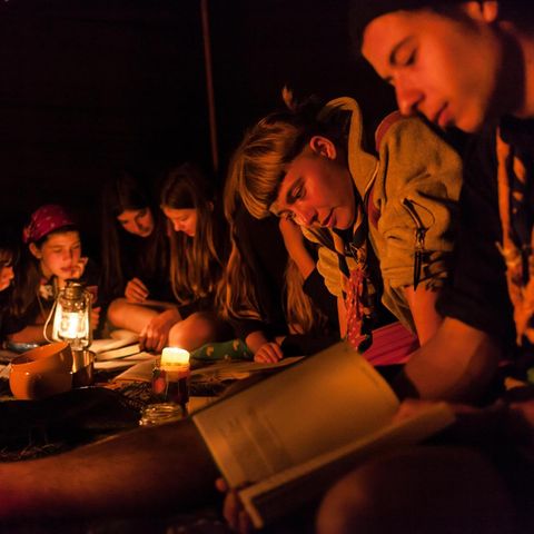 Pfadfinder sitzen um ein Lagerfeuer