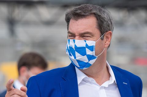 Bayerns Ministerpräsident Markus Söder trägt zum blauen Jackett einen Mund-Nasen-Schutz in weiß-blau