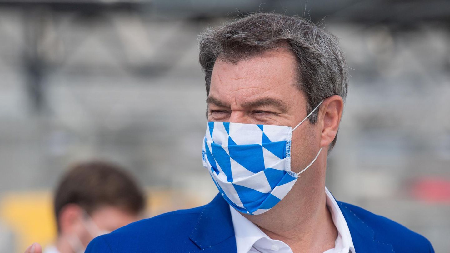 Bayerns Ministerpräsident Markus Söder trägt zum blauen Jackett einen Mund-Nasen-Schutz in weiß-blau
