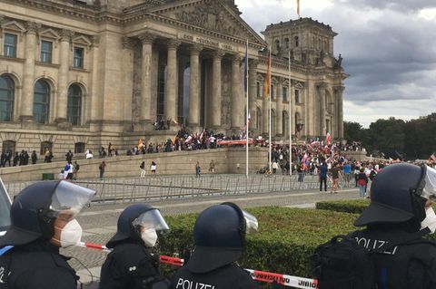 Teilnehmer der Kundgebung gegen die Corona-Maßnahmen stehen vor dem Reichstag in Berlin