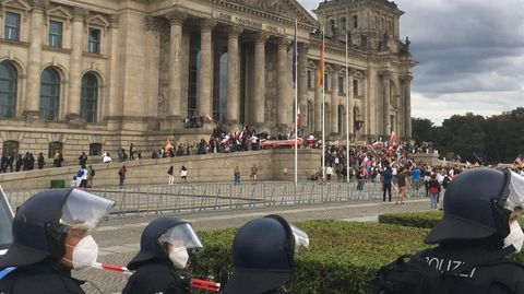 Teilnehmer der Kundgebung gegen die Corona-Maßnahmen stehen vor dem Reichstag in Berlin