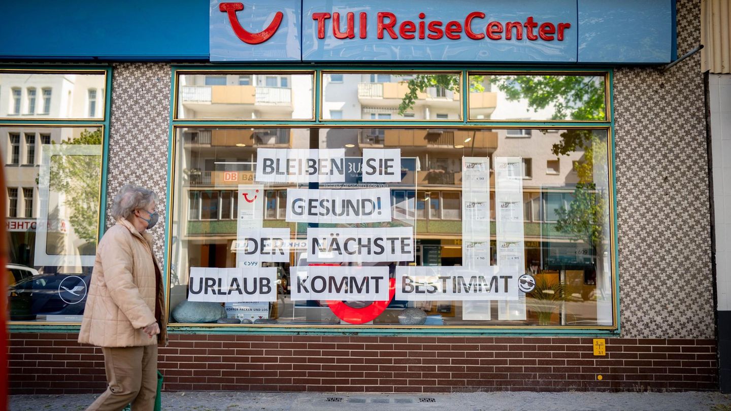  Eine Passantin mit Mund-Nasenschutz geht an einem Reisebüro vorbei