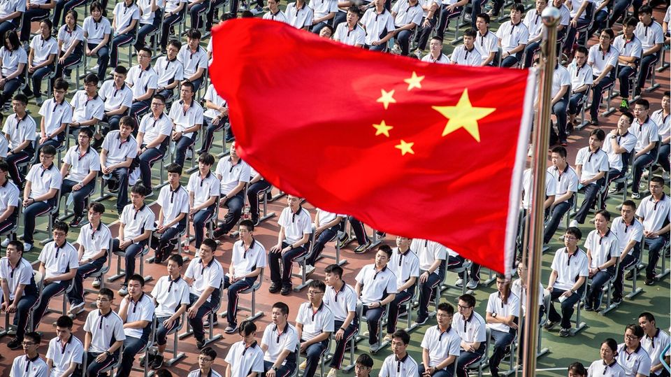 Wuhan, China. Den 100. Geburtstag feiert die Wuhan High School, indem sie ihre Schülerinnen und Schüler zu Beginn des neuen Schuljahres in Reih' und Glied hinsetzt. Partystimmung kommt da eher nicht auf.