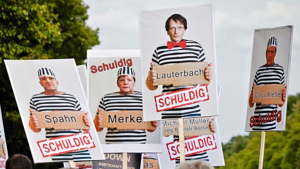 Plakate mit Fotomontagen und Bildern von Angela Merkel, Karl Lauterbach, Jens Spahn und Claus Kleber als Strafgefangene und Aufschrift Schuldig auf der Demonstration der Protestbewegung Querdenken 711 im Tiergarten in Berlin. Die Demonstration richtet ... Plakate mit Fotomontagen und Bildern von Politikern und Journalisten