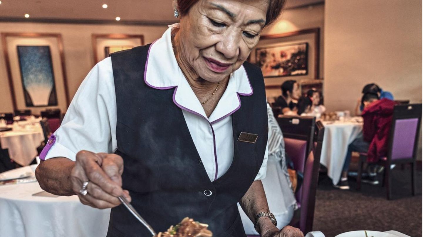 Eine Frau serviert Haifischsuppe
