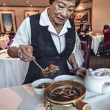 Eine Frau serviert Haifischsuppe