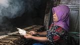 Eine Frau grillt das Fleisch eines Haifischs