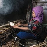 Eine Frau grillt das Fleisch eines Haifischs