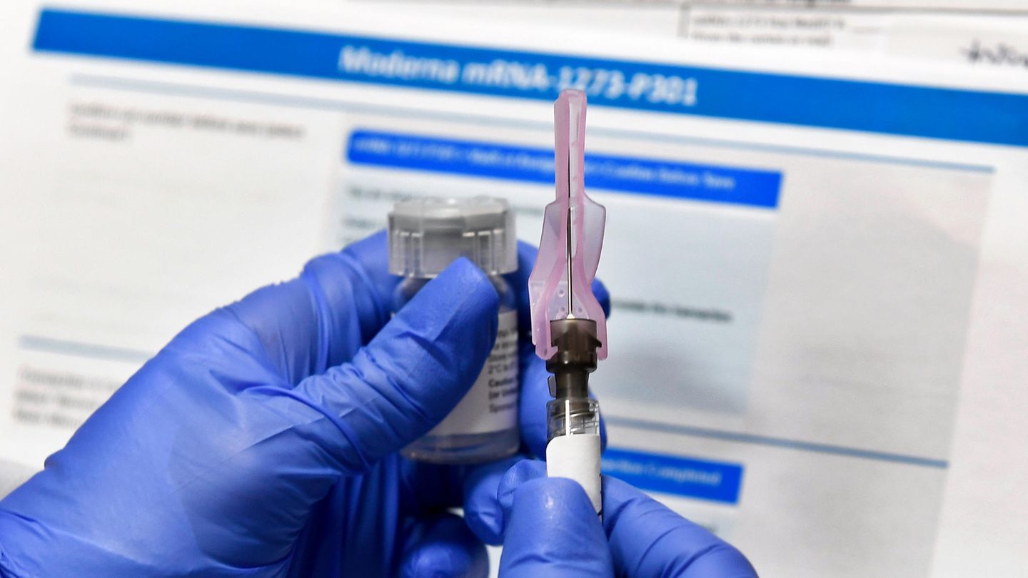 Corona-Impfstoff-Studie in Binghampton - Nadel in der Hand vor Bildschirm