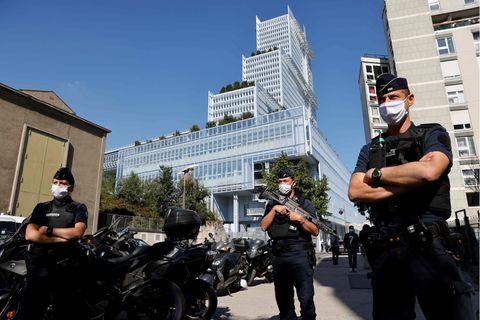 Drei französische Polizisten stehen bewaffnet vor einem Gebäude in Paris, in dem der "Charlie Hebdo"-Prozess stattfindet