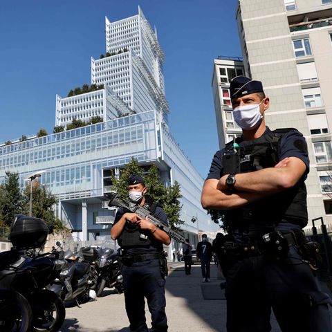 Drei französische Polizisten stehen bewaffnet vor einem Gebäude in Paris, in dem der "Charlie Hebdo"-Prozess stattfindet
