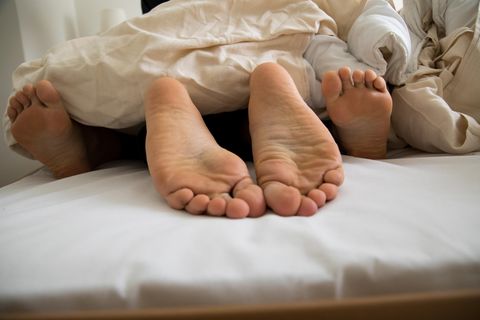Eine junge Frau und ein junger Mann liegen gemeinsam in einem Bett (gestellte Szene)