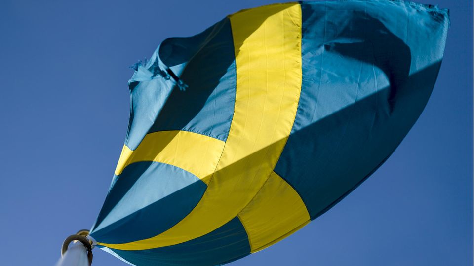 Die schwedische Flagge weht vor blauem Himmel im Wind Die schwedische Flagge weht vor blauem Himmel im Wind