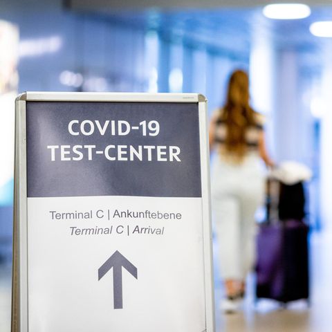 Ein Schild weist Reisende auf das Corona-Testzentrum am Flughafen Hannover-Langenhagen hin