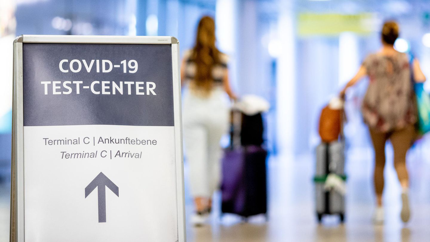 Ein Schild weist Reisende auf das Corona-Testzentrum am Flughafen Hannover-Langenhagen hin