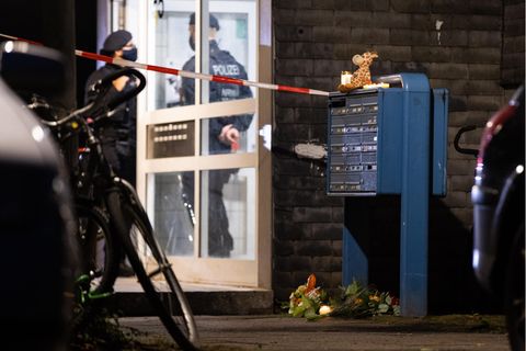 Polizisten stehen im Eingang eines Wohnhauses