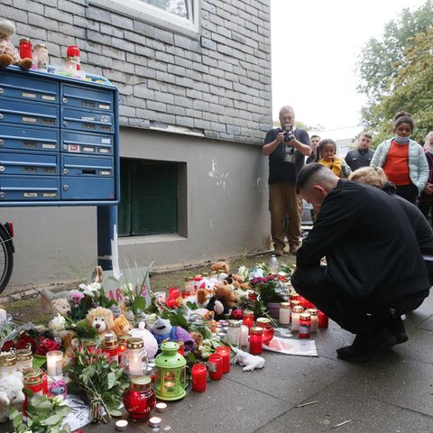 Solingen: Trauende knien vor Blumen, Kerzen und Stofftieren vor dem Haus, wo fünf tote Kinder entdeckt worden waren