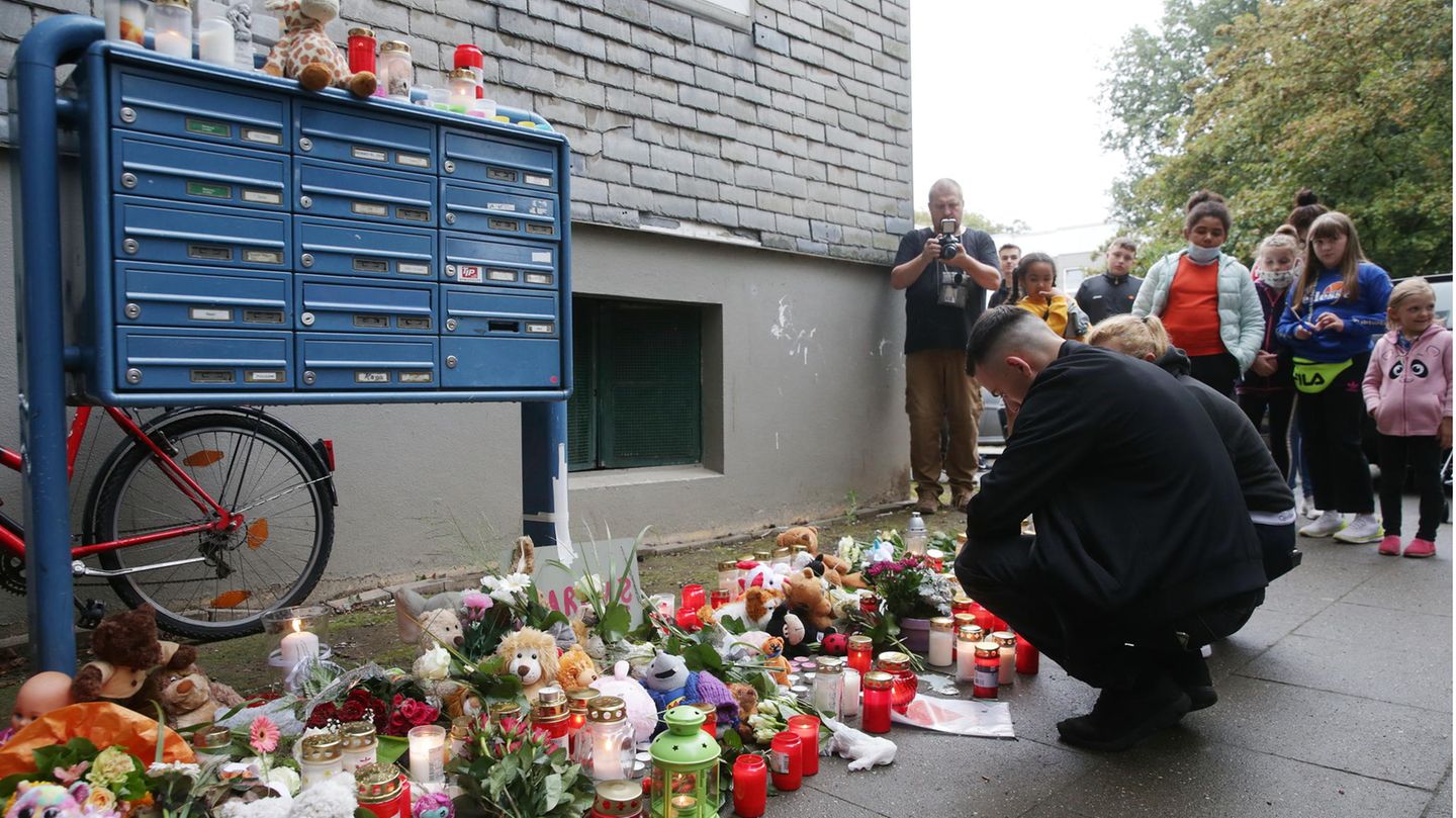 Solingen: Trauende knien vor Blumen, Kerzen und Stofftieren vor dem Haus, wo fünf tote Kinder entdeckt worden waren