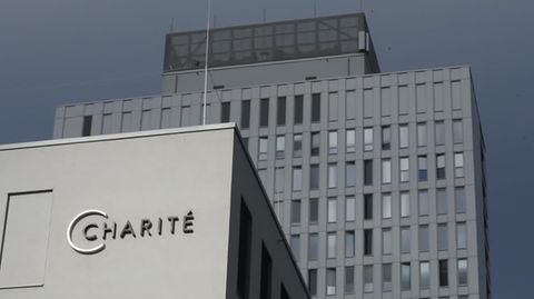 Zwei graue Hochhäuser stehen vor dem Himmel über Berlin. Am vorderen ist der metallene Schriftzug "Charité" angebracht