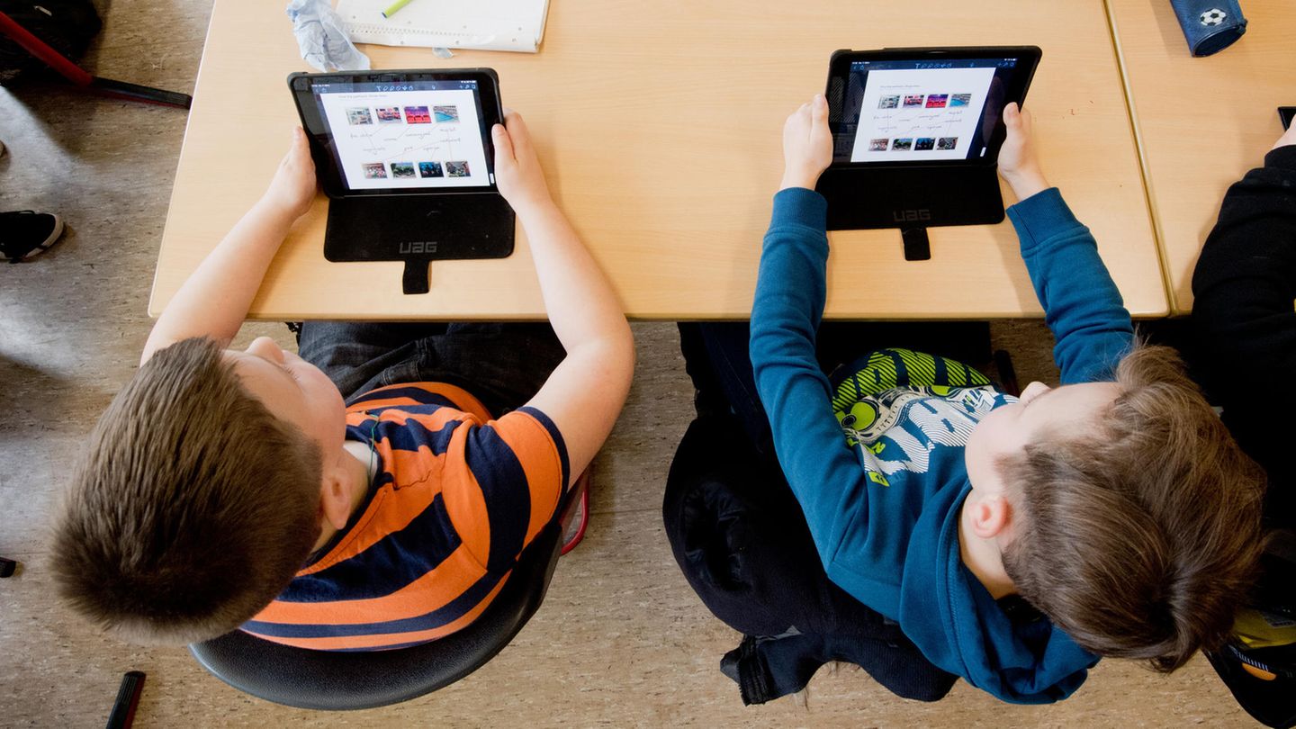 Schüler einer 5. Klasse lernen mit iPads im Englischunterricht