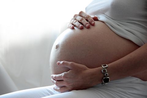Coronavirus Schwangerschaft: Eine schwangere Frau fasst sich an den Bauch