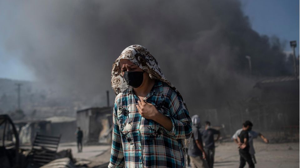 Eine Frau mit Mund- und Kopfbedeckung im zerstörten Flüchtlingslager Moria auf Lesbos
