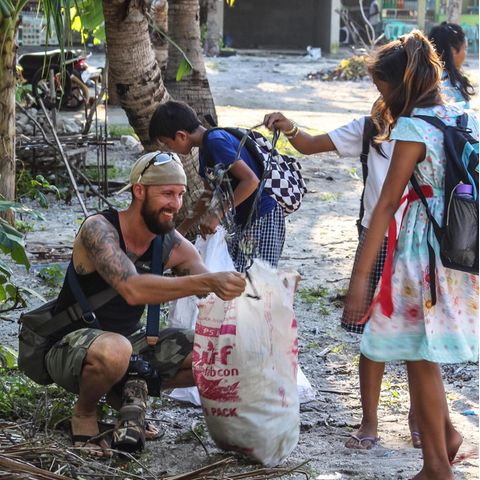 Robert Marc Lehmann mit Kindern beim Müll sammeln am Strand