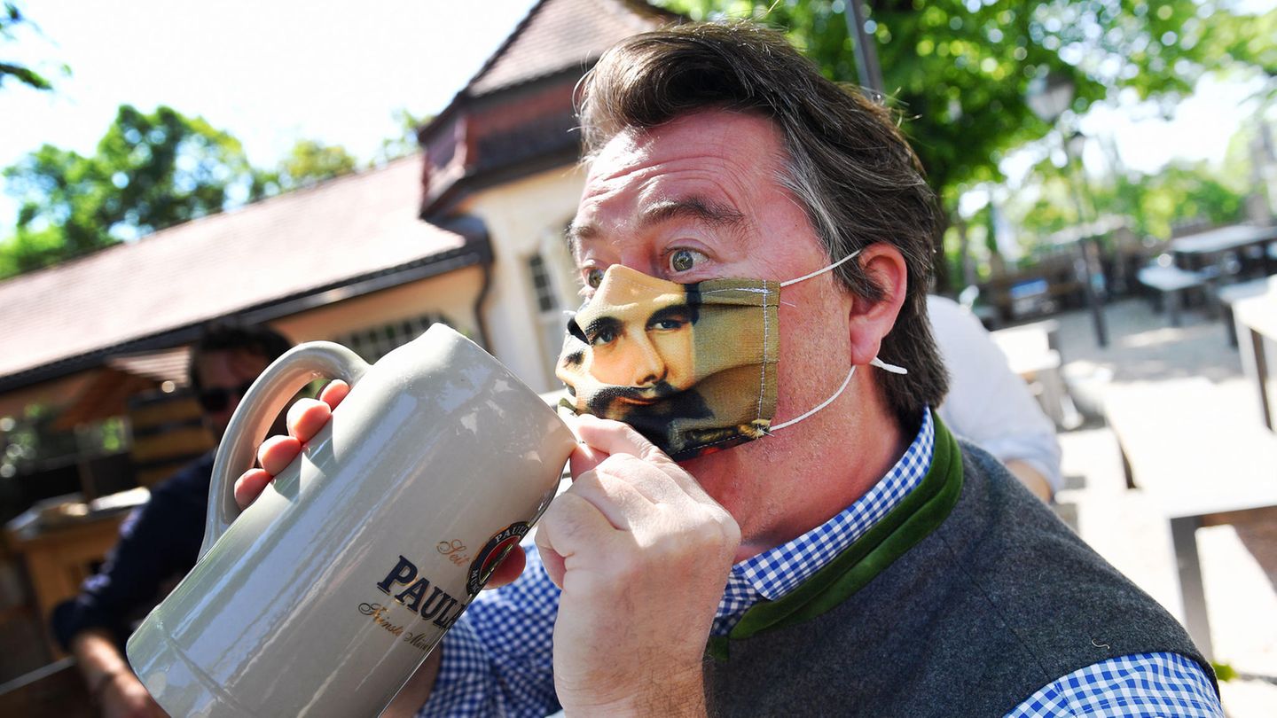 Ein Mann trinkt Bier im Paulaner-Biergarten