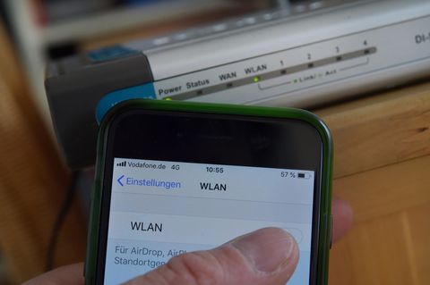 Wlan-Signal verstärken: Smartphone-Nutzer vor Wlan-Router