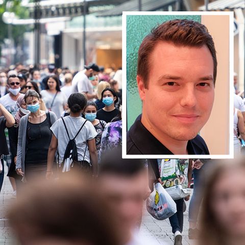 Passanten gehen durch eine Einkaufsstraße