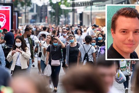 Passanten gehen durch eine Einkaufsstraße
