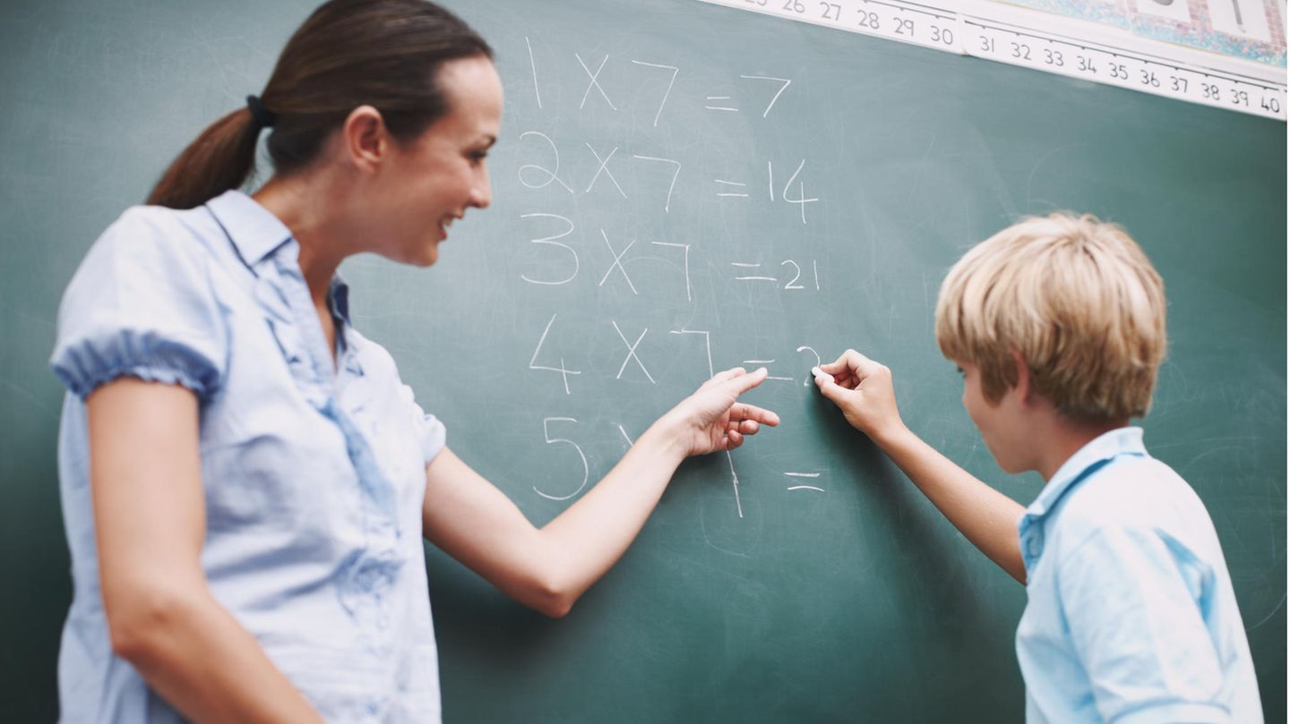 Mathematiklehrerin und Schüler an der Tafel