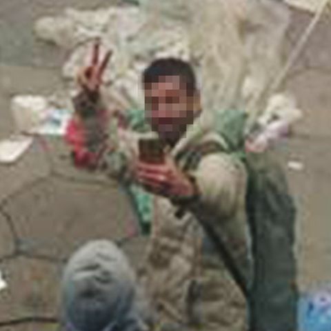 Ein Flüchtling macht ein Selfie vor einem brennenden Zelt.