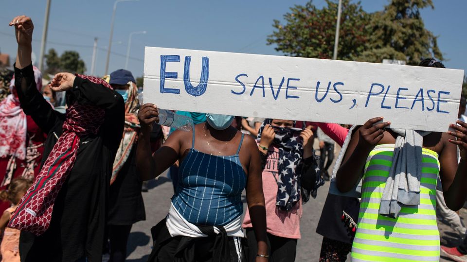 Migranten protestieren auf Lesbos mit einem Schild "EU save us, please!"