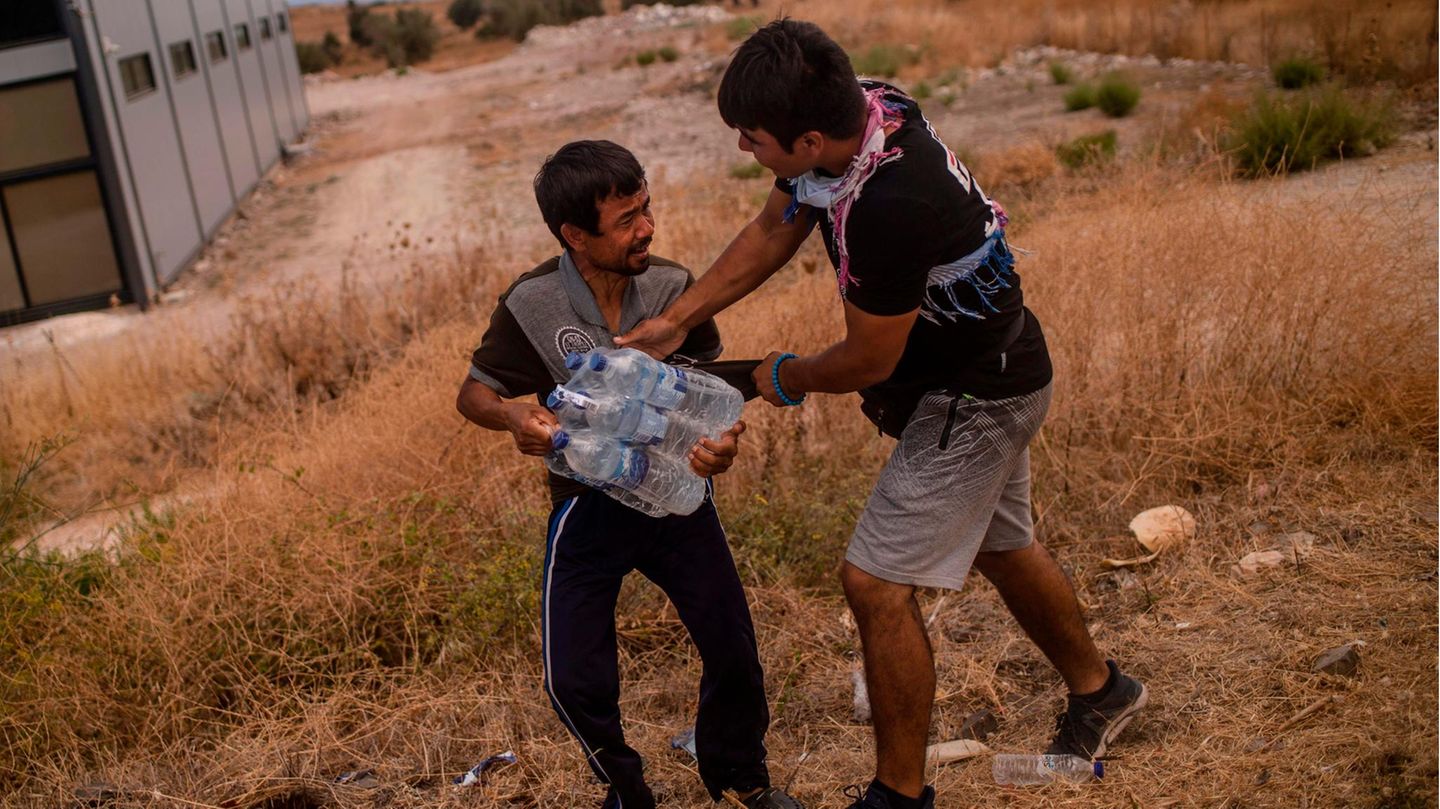 Zwei Migranten streiten sich um Wasserflaschen
