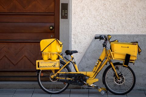 Post-Fahrrad lehnt an einer Hauswand