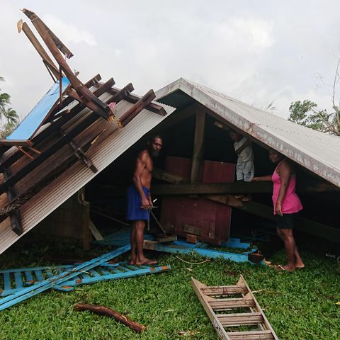 Familie steht auf Vanuatu in den Trümmern ihres durch einen Wirbelsturm zerstörten Hauses