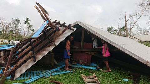 Familie steht auf Vanuatu in den Trümmern ihres durch einen Wirbelsturm zerstörten Hauses
