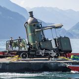 Bild 1 von 9 der Fotostrecke zum Klicken:   Baujahr 1873: Die weltweit noch einzige fahrbare Zahnraddampflok wird von Luzern über den Vierwaldstättersee geschleppt.