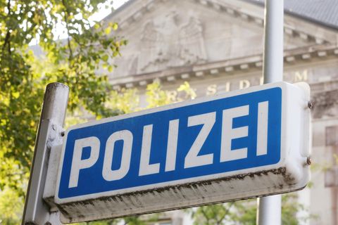 Vor dem Eingang zum Essener Polizeipräsidium ist ein blaues Polizeischild zu sehen
