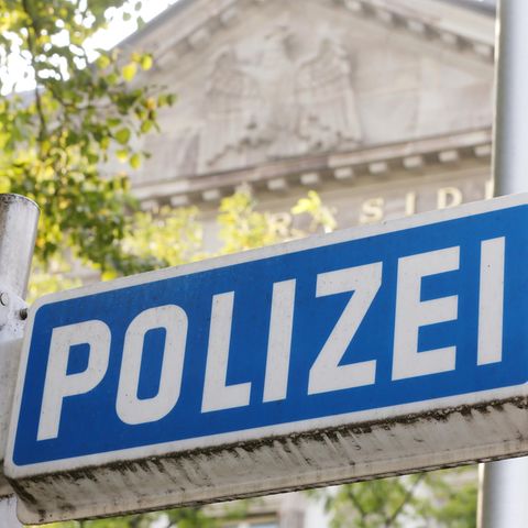 Vor dem Eingang zum Essener Polizeipräsidium ist ein blaues Polizeischild zu sehen
